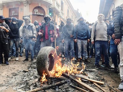 Des manifestants opposés à la hausse du prix du carburant font brûler des pneus lors d'affrontements avec la police, le 9 octobre 2019 à Quito, en Equateur - Martin BERNETTI [AFP]