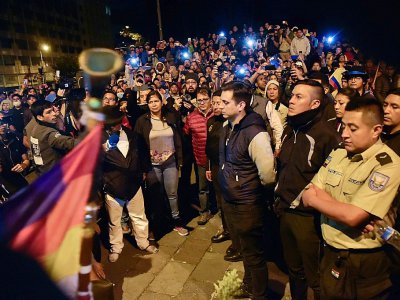 Les membres des forces de l'ordre (D), retenus par des manifestants, attendent d'être remis à des représentants des Naions unies à Quito le 10 octobre 2019 - RODRIGO BUENDIA [AFP]