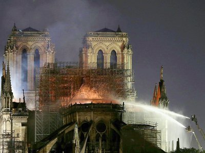 Des pompiers arrosent la toiture de la cathédrale Notre-Dame dans la nuit du 15 au 16 avril 2019, à Paris. - LUDOVIC MARIN [AFP/Archives]
