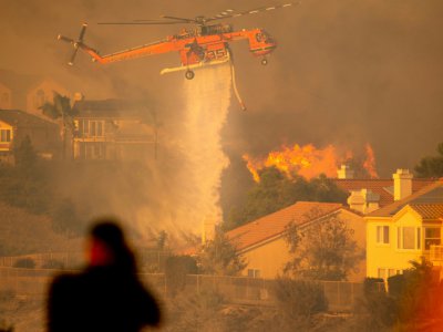 Un hélicoptère largue de l'eau pour tenter de stopper l'incendie baptisé "Saddleridge Fire" qui progresse à une vingtaine de km au nord de Los Angeles, le 11 octobre 2019 - Josh Edelson [AFP]