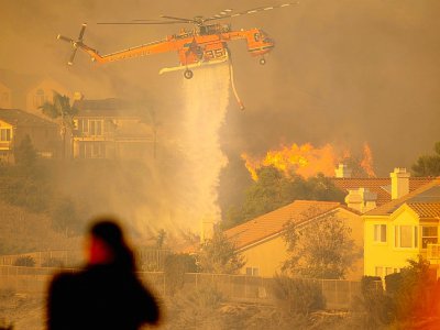Un hélicoptère largue de l'eau pour tenter de stopper l'incendie baptisé "Saddleridge Fire" qui progresse à une vingtaine de km au nord de Los Angeles, le 11 octobre 2019 - Josh Edelson [AFP]