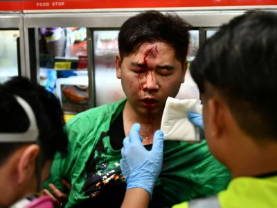 Des médecins bénévoles soignent un homme attaqué durant des affrontements avec des manifestants, à Hong Kong le 13 octobre 2019 - Anthony WALLACE [AFP]