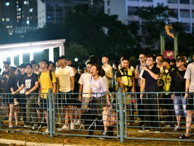 Des habitants invectivent des policiers après l'arrestation d'un homme durant des manifestations, à Hong Kong le 13 octobre 2019 - Anthony WALLACE [AFP]