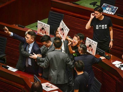 Des députés pro-démocratie huent la cheffe de l'exécutif Carrie Lam et brandissent des affiches, au Parlement de Hong Kong le 16 octobre 2019 - Ed JONES [AFP]
