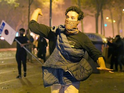 Des manifestants indépendantistes catalans lancent des projectiles sur les policiers à Barcelone le 16 octobre 2019 - LLUIS GENE [AFP]
