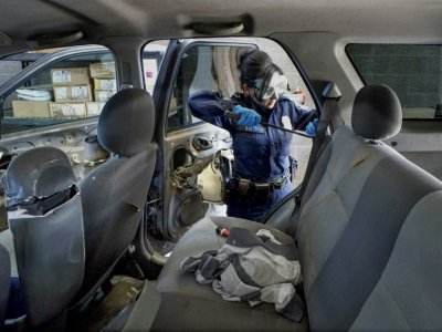 Une agente des douanes américaines cherche de la drogue dans un véhicule au poste-frontière californien de San Ysidro, le 2 octobre 2019 - SANDY HUFFAKER [AFP]