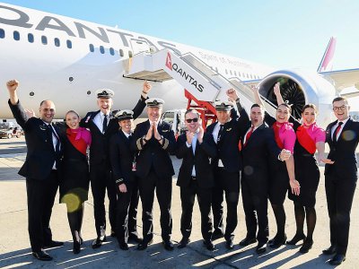 Le PDG de Qantas Alan Joyce (c) entouré des membres de l'équipage du vol le plus long de l'histoire posent devant l'appareil, le 20 octobre 2019 à Sydney - DAVID GRAY [QANTAS/AFP]