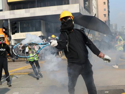 Un manifestant renvoie avec une raquette de tennis une grenade lacrymogène tirée par la police, dans le quartier de Tsim Sha Tsui, le 20 octobre 2019 à Hong Kong - Dale DE LA REY [AFP/Archives]