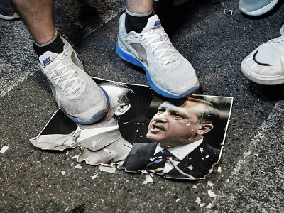 Des protestataires piétinent une photo associant le président turc Recep Tayyip Erdogan et le leader nazi Adolf Hitler pendant une manifestation contre l'offensive turque en Syrie devant l'ambassade américaine à Athènes, le 17 octobre 2019. - Louisa GOULIAMAKI [AFP]
