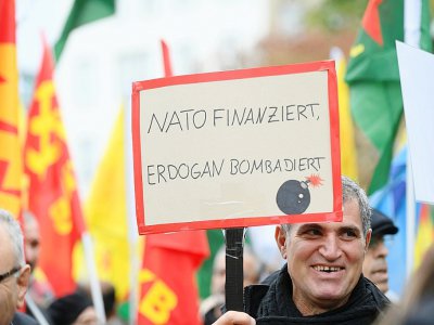 Un protestataire brandit une pancarte "L'Otan finance, Erdogan bombarde", durant une manifestation pro-kurde à Cologne, dans l'ouest de l'Allemagne, le 19 octobre 2019. - Ina Fassbender [AFP]
