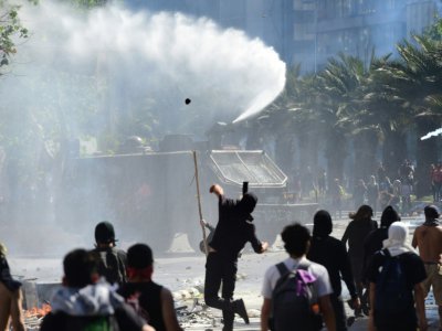 Affrontements entre manifestants et policiers anti-émeute, à Santiago le 21 octobre 2019 - Martin BERNETTI [AFP]