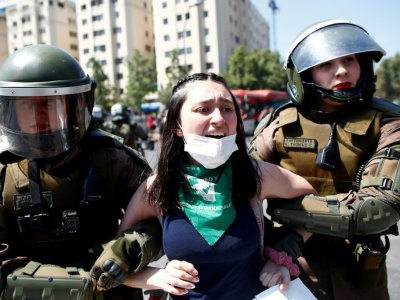 La police anti-émeutes arrête une manifestante, à Santiago le 21 octobre 2019 - Pablo VERA [AFP]