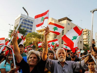 Munis de drapeaux, des Libanais manifestent contre la classe politique à Saïda, dans le sud du Liban le 21 octobre 2019 - Mahmoud ZAYYAT [AFP]