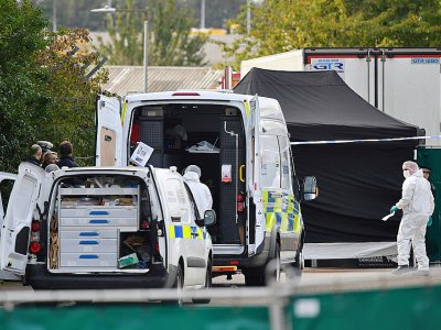Des policiers britanniques en combinaisons près du camion frigorifique dans lequel 39 morts ont été découverts à Grays, à l'est de Londres, le 23 octobre 2019 - Ben STANSALL [AFP]