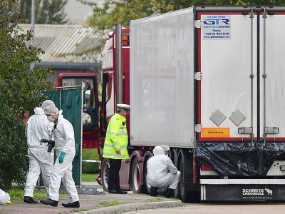 Des policiers britanniques en combinaisons étanches examinent le camion frigorifique dans lequel 39 morts ont été découverts à Grays, à l'est de Londres, le 23 octobre 2019 - Ben STANSALL [AFP]