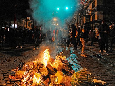 Des partisans de l'opposition se tiennent derrière un feu lors d'affrontements avec les forces de l'ordre à La Paz, le 24 octobre 2019 - JORGE BERNAL [AFP]