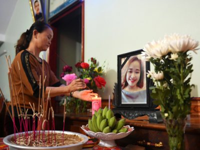 Une proche de Bui Thi Nhung, dont sa famille craint qu'elle soit un des 39 migrants trouvés morts dans un camion en Grande-Bretagne, devant un autel improvisé dans la maison de la jeune femme, dans le centre du Vietnam, le 26 octobre 2019 - NHAC NGUYEN [AFP]
