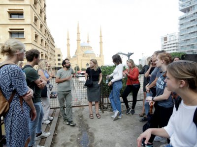 Jamil Mouawad (3e-G), professeur en sciences politiques de l'Université américaine de Beyrouth, donne un cours sur les espaces publics sur "L'oeuf", bâtiment emblématique en béton au toit oblong à moitié en ruines, à Beyrouth le 24 octobre 2019 - ANWAR AMRO [AFP]