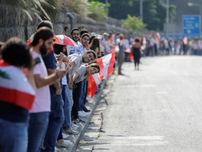 Une chaîne humaine est formée par des manifestants, ici à Nahr al-Kalb dans le nord de Beyrouth, au Liban - JOSEPH EID [AFP]