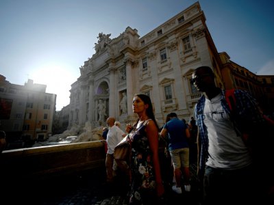 Kaba, arrivé de Guinée, guide des touristes à travers Rome, et ici, près de la Fontaine de Trevi - Filippo MONTEFORTE [AFP]