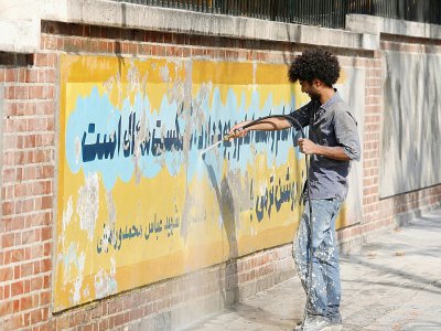 Un Iranien efface le 29 septembre 2019 une fresque murale peinte sur les murs de l'ambassade des Etats-Unis à Téhéran pour commémorer la prise d'otages du personnel diplomatique américain en 1979 - ATTA KENARE [AFP/Archives]