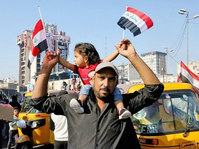 Un manifestant irakien porte une petite fille sur ses épaules sur la place Tahrir dans la capitale irakienne Bagdad, le 1er novembre 2019 - SABAH ARAR [AFP]
