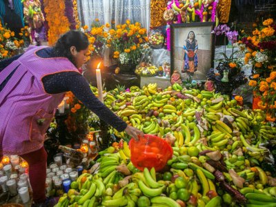 Une femme offre des fruits en offrande pour le Jour des morts à Santa Fe de la Laguna, dans l'Etat de   Michoacan, au Mexique, le 31 octobre 2019 - ENRIQUE CASTRO [AFP]