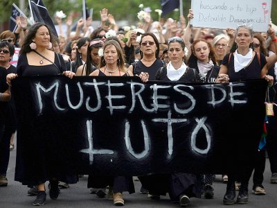 Des femmes vêtues de noir en signe de deuil pour les vingt morts survenues en deux semaines de conflit social, le 1er novembre 2019 à Santiago du Chili - CLAUDIO REYES [AFP]