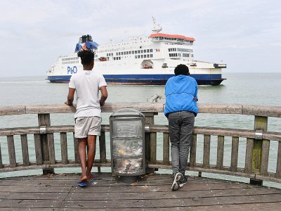 Des migrants venant d'Erythrée regardent un ferry arrivant de Grande-Bretagne accoster au port de Calais, le 12 août 2019 - Denis Charlet [AFP/Archives]