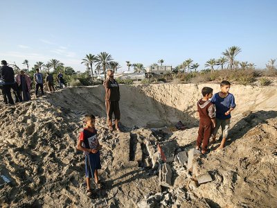 Des enfants palestiniens marchent autour d'un cratère creusé par une frappe israélienne, dans le sud de la bande de Gaza, le 2 novembre 2019 - SAID KHATIB [AFP]