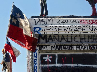 Un manifestant devant une statue taguée à Santiago du Chili le 3 novembre 2019 - CLAUDIO REYES [AFP]