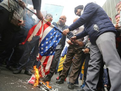 Des Iraniens mettent le feu à un drapeau américain à Téhéran, le 4 novembre 2019 - ATTA KENARE [AFP]