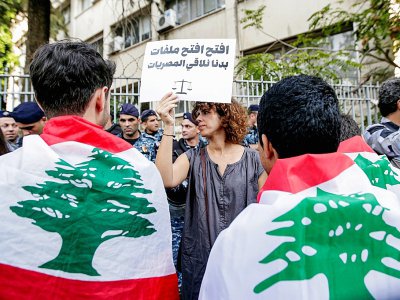 Une femme tient une pancarte appelant à la transparence lors d'une manifestation antigouvernementale devant le Palais de Justice à Beyrouth, le 6 novembre 2019 - ANWAR AMRO [AFP]