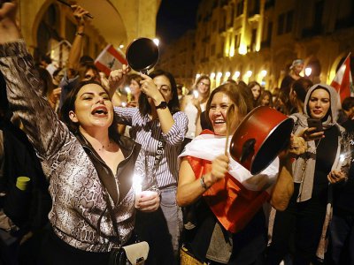 Des Libanaises tapent sur des casseroles et tiennent des bougies le 6 novembre 2019 à Beyrouth pour exprimer leur colère contre le gouvernement - Patrick BAZ [AFP]