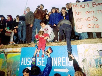 Des Allemands de l'ouest accueillent les Berlinois de l'est qui franchissent le Mur, le 22 décembre  1989 - Patrick HERTZOG [AFP/Archives]