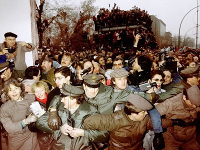 Des policiers est et ouest-allemands essaient de contenir la foule de Berlinois de l'Est qui passent à Berlin Ouest après l'ouverture des frontières, le 12 novembre 1989 - Patrick HERTZOG [AFP/Archives]