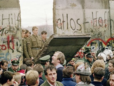 Des Berlinois de l'est regardent des soldats ouest-allemands en train d'abattre des pans du Mur à Berlin pour créer un nouveau point de passage, le 11 novembre 1989 - Gerard MALIE [AFP/Archives]