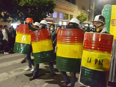 Des manifstants d'opposition se protègent avec des boucliers improvisés à La Paz le 8 novembre 2019 - AIZAR RALDES [AFP]