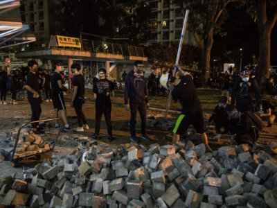Des manifestants rassemblent des pavés devant l'Université chinoise de Hong Kong, le 12 novembre 2019 - DALE DE LA REY [AFP]