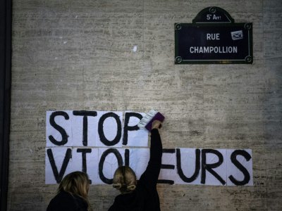 Des manifestantes collent "Stop violeurs" près du cinéma où était projeté en avant-première le nouveau film de Roman Polanski, le 12 novembre 2019 à Paris - Christophe ARCHAMBAULT [AFP]