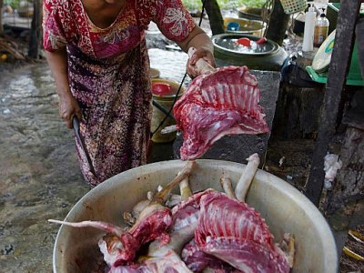 Une femme prépare de la viande de chien pour la vendre, dans un abattoir de la province de Siem Reap, le 25 octobre 2019 - TANG CHHIN Sothy [AFP]