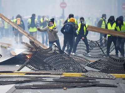Des manifestants "gilets jaunes" utilisent les grilles entourant le pied des arbres pour bloquer une rue, le 1er décembre 2019 à Paris - Alain JOCARD [AFP]