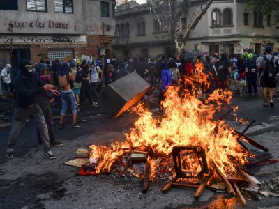 Des manifestants allument un bûcher le 14 novembre 2019 à Santiago lors de protestations anti-gouvernementales et de la commémoration de la mort d'un Mapuche tué par la police un an auparavant - Martin BERNETTI [AFP]