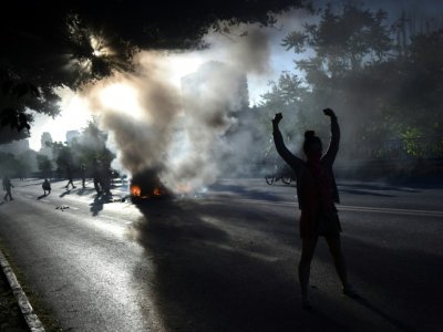 Des manifestants allument un feu dans la rue à Santiago du Chili, le 15 novembre 2019 - RODRIGO ARANGUA [AFP]