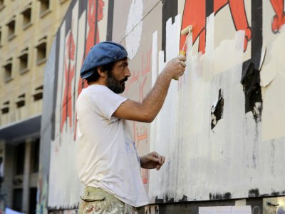 Un artiste et militant libanais Selim Mawad retouche ses peintures le 6 novembre 2019 à Beyrouth - JOSEPH EID [AFP]