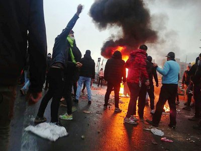Des manifestants se rassemblent autour d'un feu à Téhéran en Iran, le 16 novembre 2019 - - [AFP]