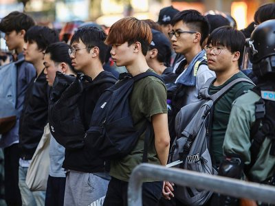 Des jeunes sont arrêtés par les forces de l'ordre à proximité du campu de l'Université polytechique de Hong Kong, le 18 novembre 2019 - DALE DE LA REY [AFP]