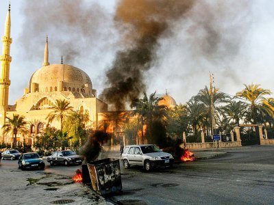 Des véhicules circulent sur un axe où des manifestants antigouvernementaux font brûler des pneus, le 19 novembre 2019 à Saïda, dans le sud du Liban - Mahmoud ZAYYAT [AFP]