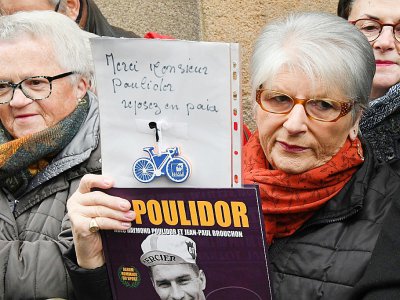 Une femme brandissant la photo de Raymond Poulidor avec l'inscription "Merci Poulidor, reposez en paix", lors de ses funérailles à Saint-Léonard-de-Noblat, le 19 novembre 2019 - MEHDI FEDOUACH [AFP]
