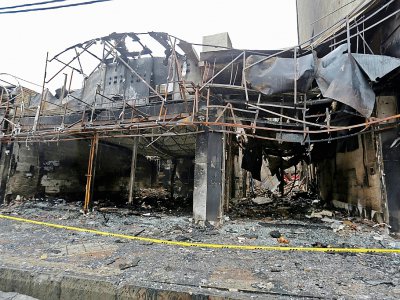 Photo de magasins incendiés durant les manifestations, à Chahriar, en banlieue ouest de Téhéran, le 20 novembre 2019 - ATTA KENARE [AFP]